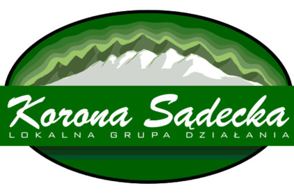 Logo LGD Korona sądecka - zielona elipsa z białymi szczytami gór w środku, na froncie zielony prostokąt z napisem Korona Sądecka - LOKALNA GRUPA DZIAŁANIA
